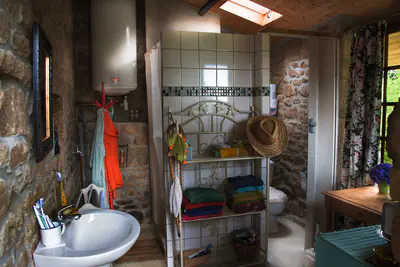 Badezimmer mit Dusche, Waschbecken und WC.